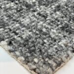 Close-up of gray wool woven carpet texture.