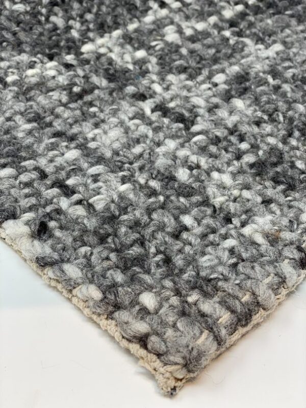 Close-up of gray wool woven carpet texture.