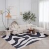 Modern living room with abstract rug and white sofa.