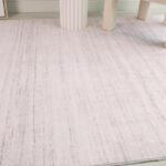 Light beige textured area rug in room corner.