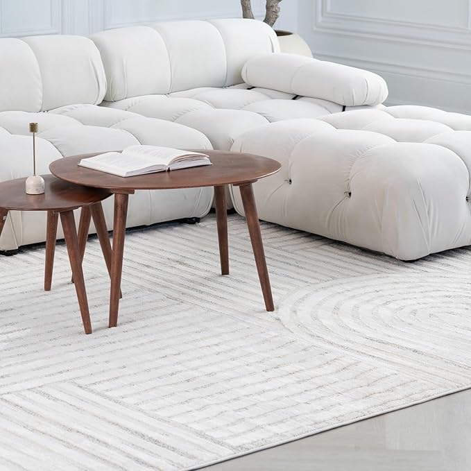 Modern living room with white sofa and tables.