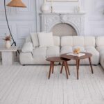 Modern living room with beige sofa and round tables.