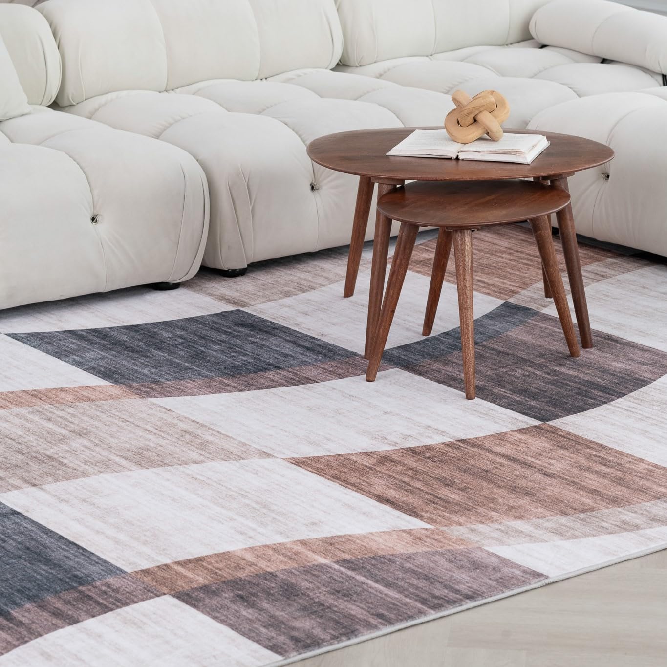 Modern living room with geometric-patterned rug and tables.