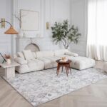 Elegant living room with white sectional sofa and plants.