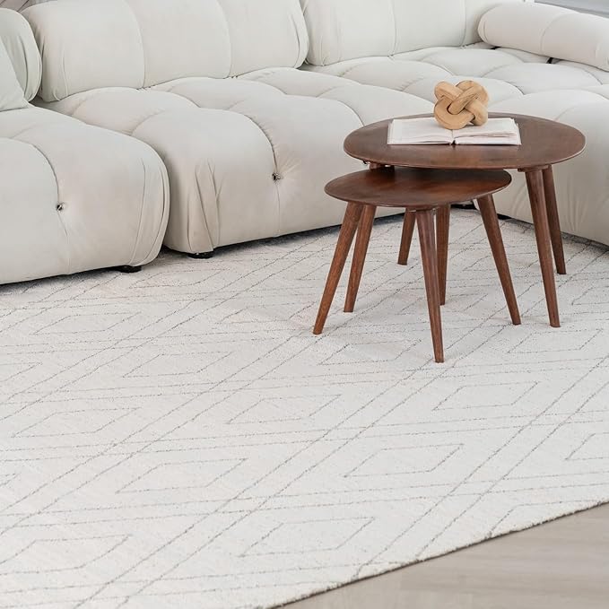 White couch with wooden coffee tables on carpet