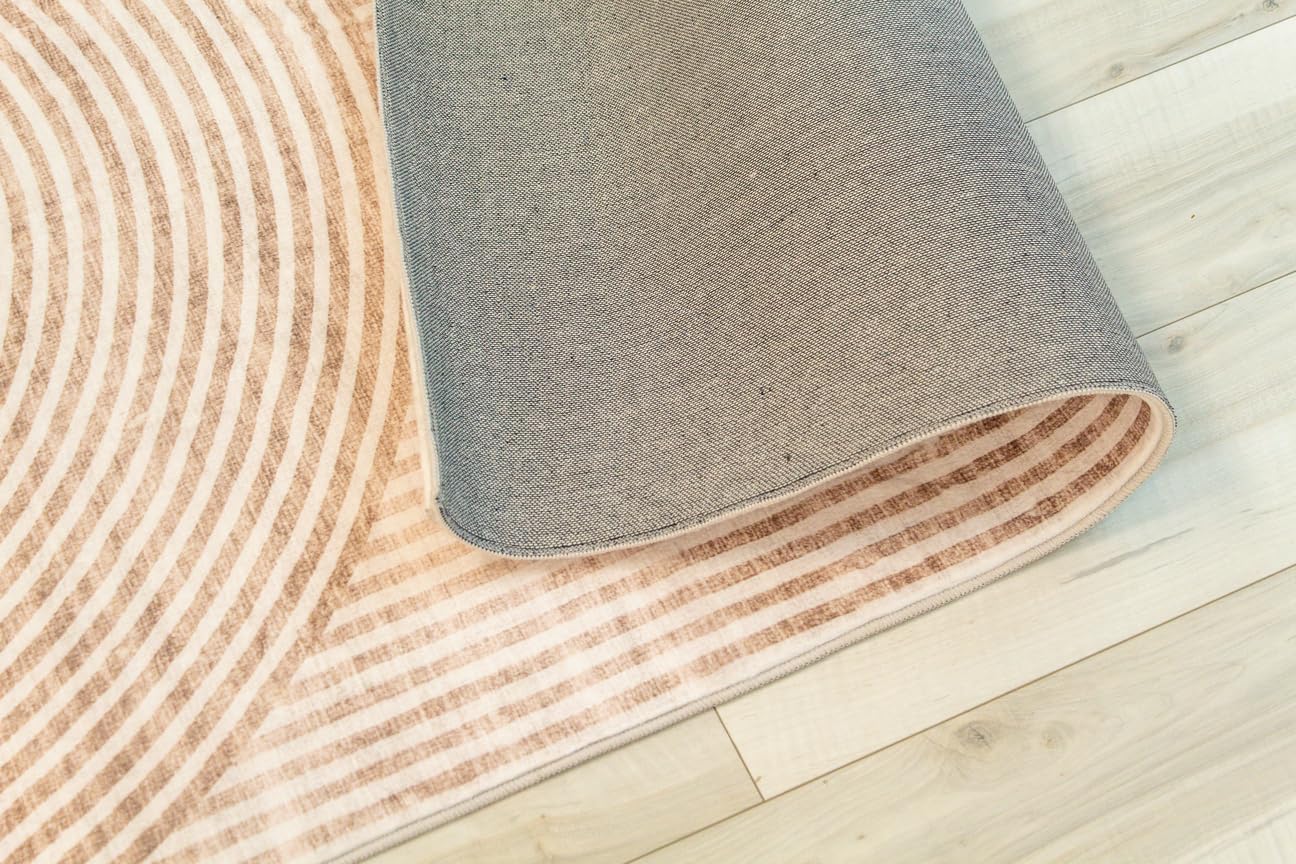 Patterned rug partially rolled on wooden floor.