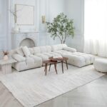 Elegant living room with white sofa and fireplace.