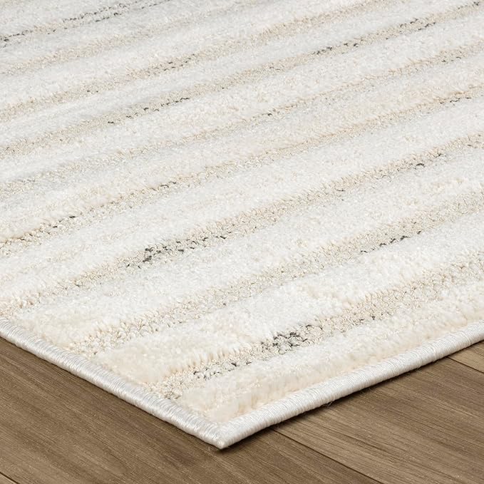 Beige striped carpet on wooden floor surface.