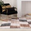 Modern chair with decorative pillows and checkered rug.