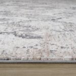 Close-up of textured woven rug on wooden floor.