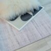 Fuzzy cushion and framed artwork on light rug