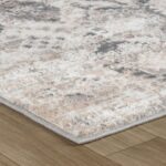 Abstract textured rug on wooden floor corner view.