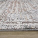 Close-up of patterned rug on wooden floor.