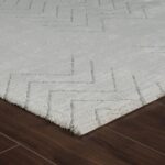 White patterned rug on wooden floor.