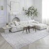 Modern living room with white sofa and rug.
