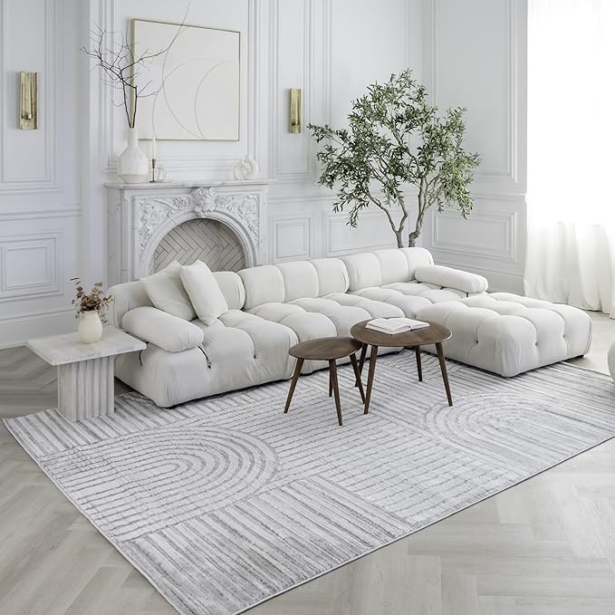 Modern living room with white sofa and rug.