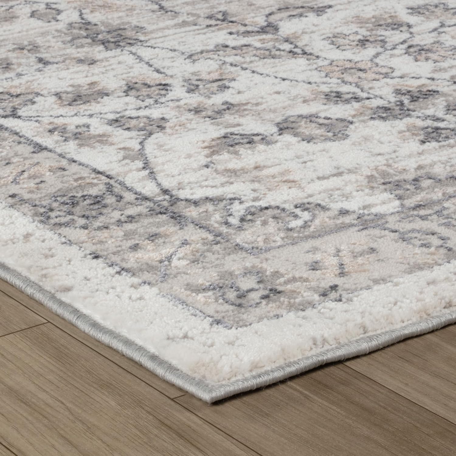 Beige and gray pattern rug on wooden floor.