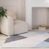 Cozy chair and geometric rug in modern living room.