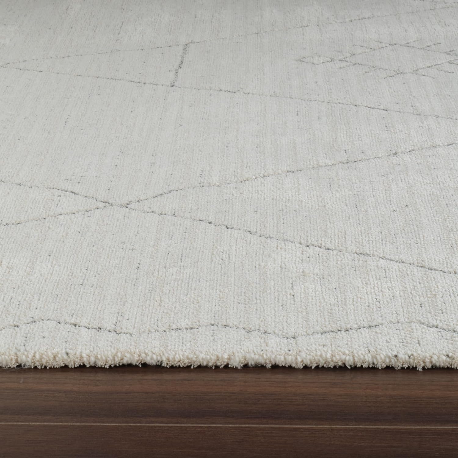 Textured white rug on dark wood floor.