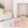 Modern living room with striped rug and chair.