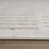 Close-up of textured white rug on wooden floor.