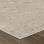 Close-up of beige textured rug on wooden floor.