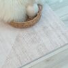 Neutral geometric rug on wooden floor.