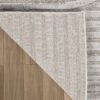 Textured beige rug corner on wooden floor.