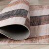 Folded plaid pattern rug on hardwood floor.