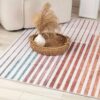 Striped rug with basket and vase decoration