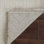 Rug corner peeled back on wooden floor