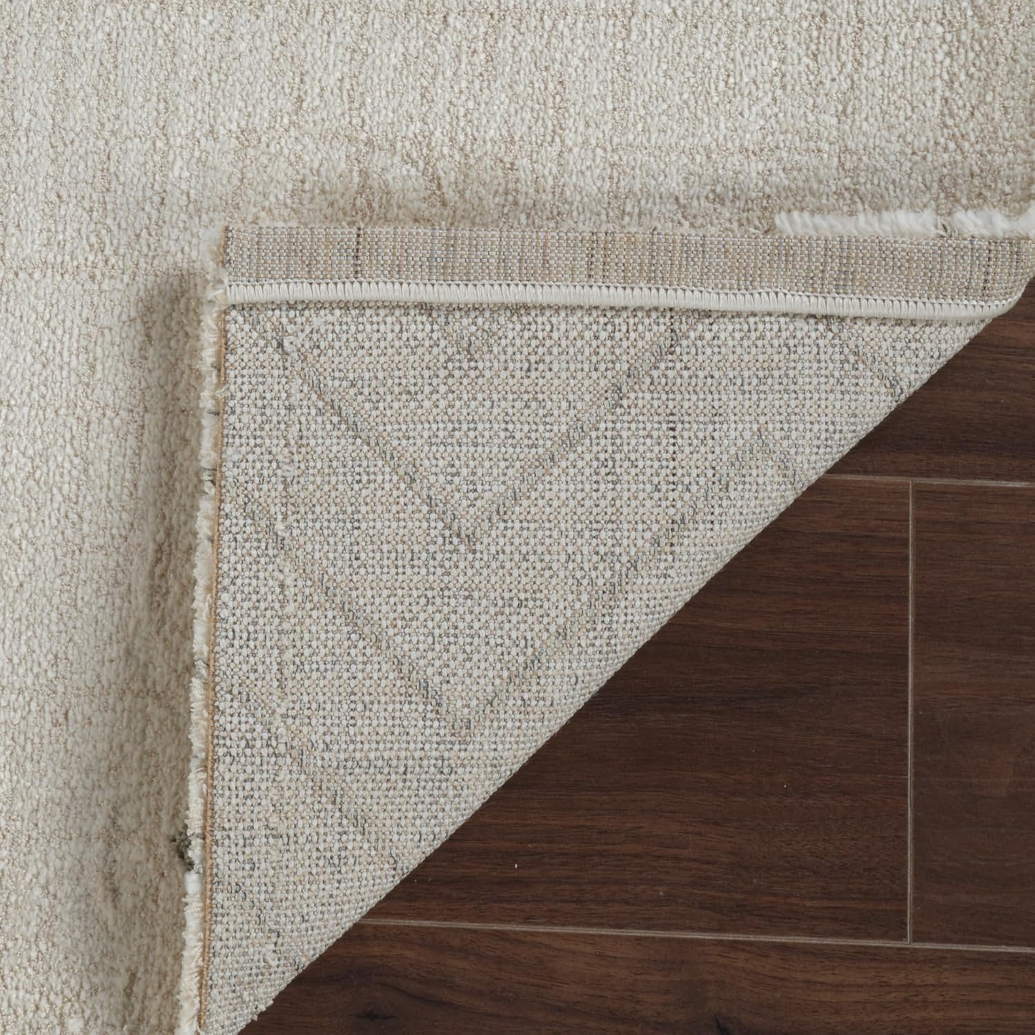 Rug corner peeled back on wooden floor
