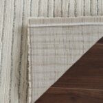 Striped rug on wooden floor corner folded
