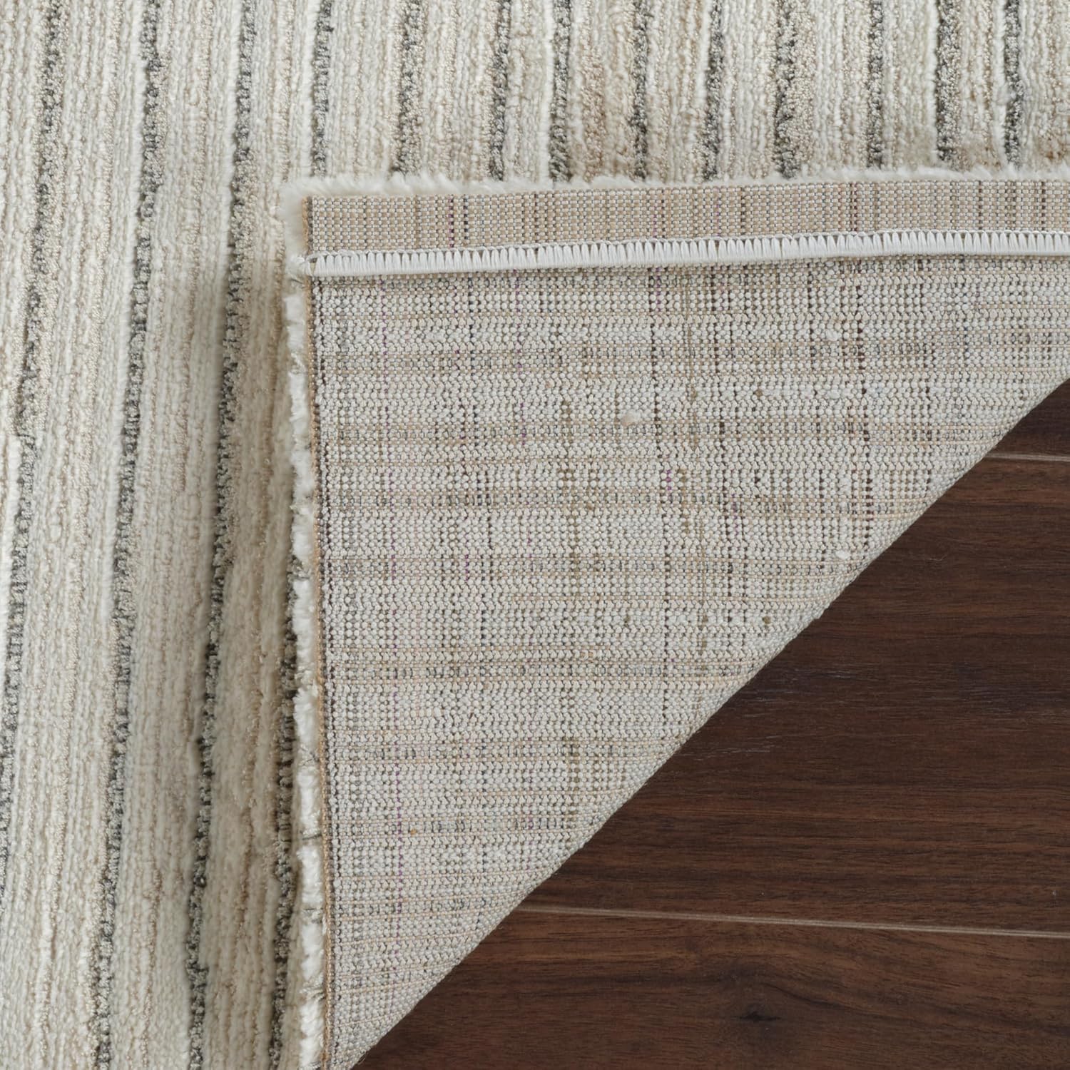 Striped rug on wooden floor corner folded