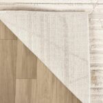 Beige area rug corner flipped on wood floor