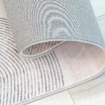 Rolled gray and white striped rug on floor