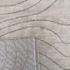 Beige rug with wavy gray lines, close-up view.