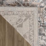 Corner of patterned rug on wooden floor.