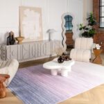 Modern living room with abstract decor and purple rug.