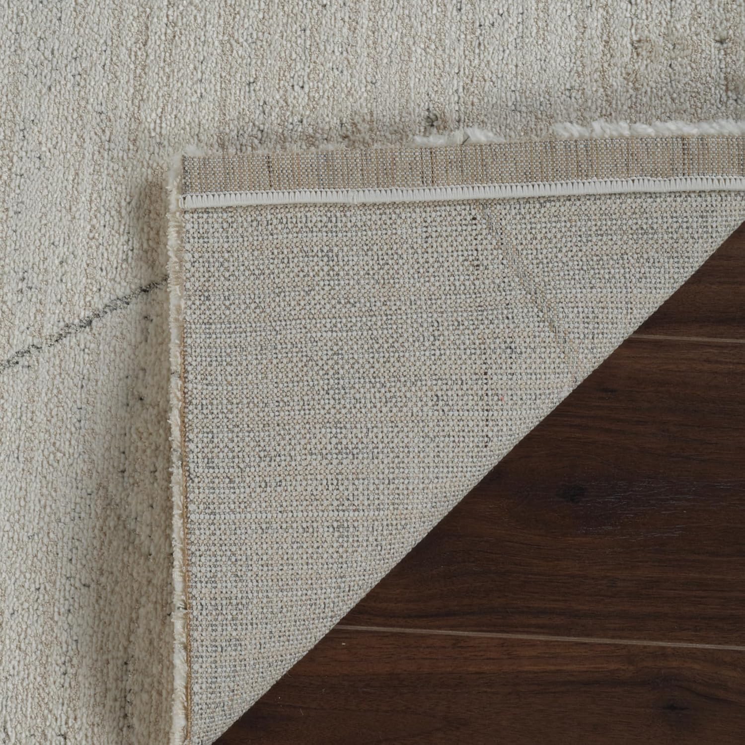 Corner of layered brown and beige rugs