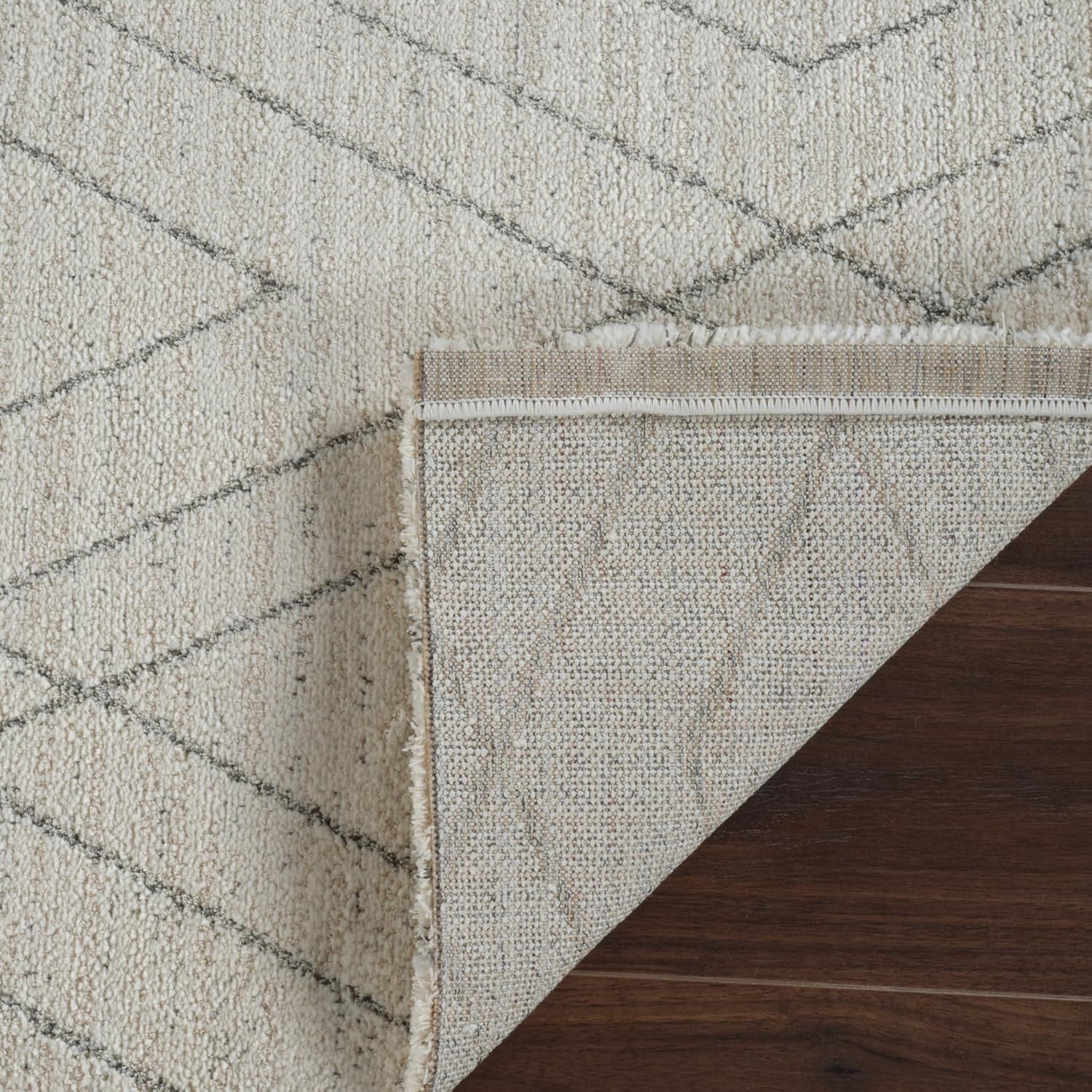 Geometric rug on wooden floor corner reveal.