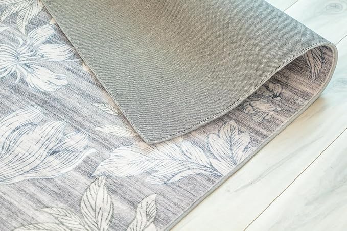 Floral rug with corner turned up on floor.