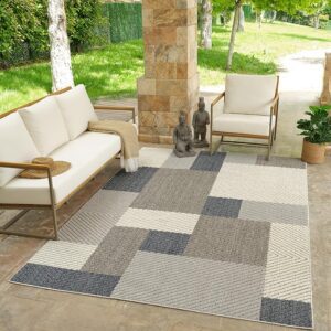 Outdoor patio with rug and wooden furniture.