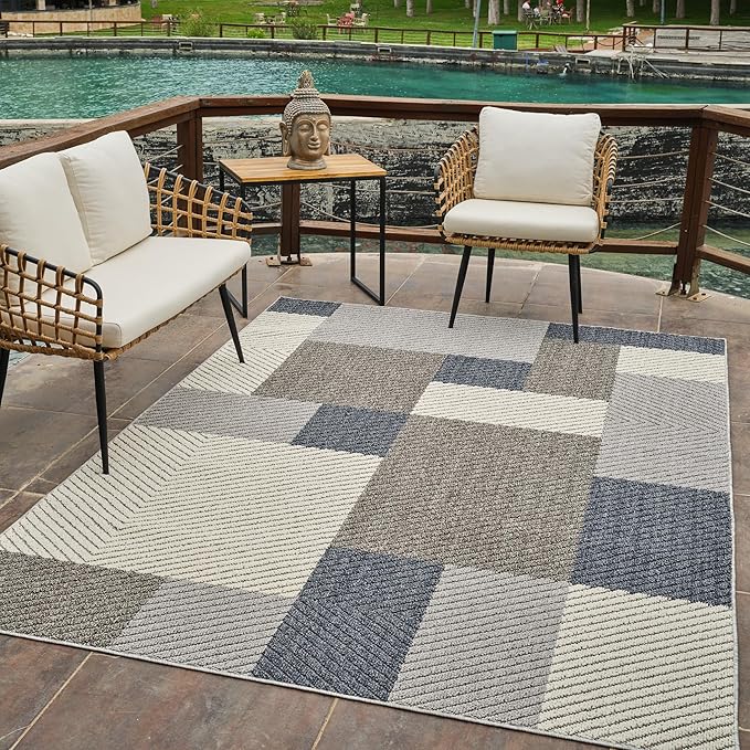 Outdoor seating with patterned rug and statue head.
