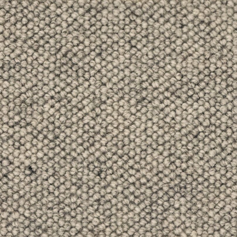 Close-up of beige textured carpet fibers.