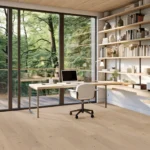 Modern home office with forest view and bookshelves.