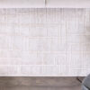 Modern white rug with geometric pattern on wooden floor.