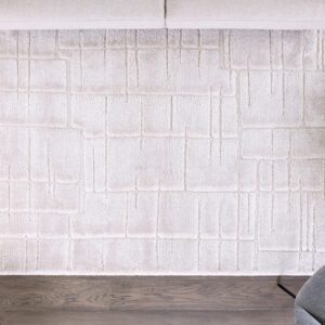 Modern white rug with geometric pattern on wooden floor.
