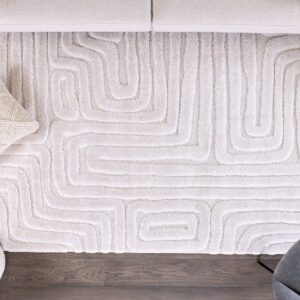 Beige rug with geometric pattern on wooden floor.