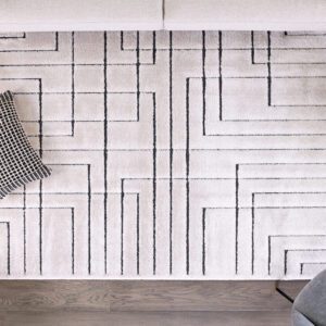 Modern geometric rug with black lines on white background.